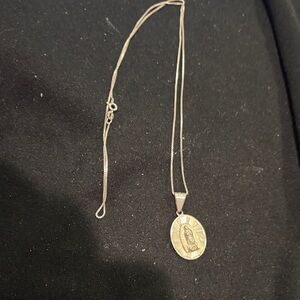 Chic Silver colored Pendant Necklace. Religious face on each side of pendant.